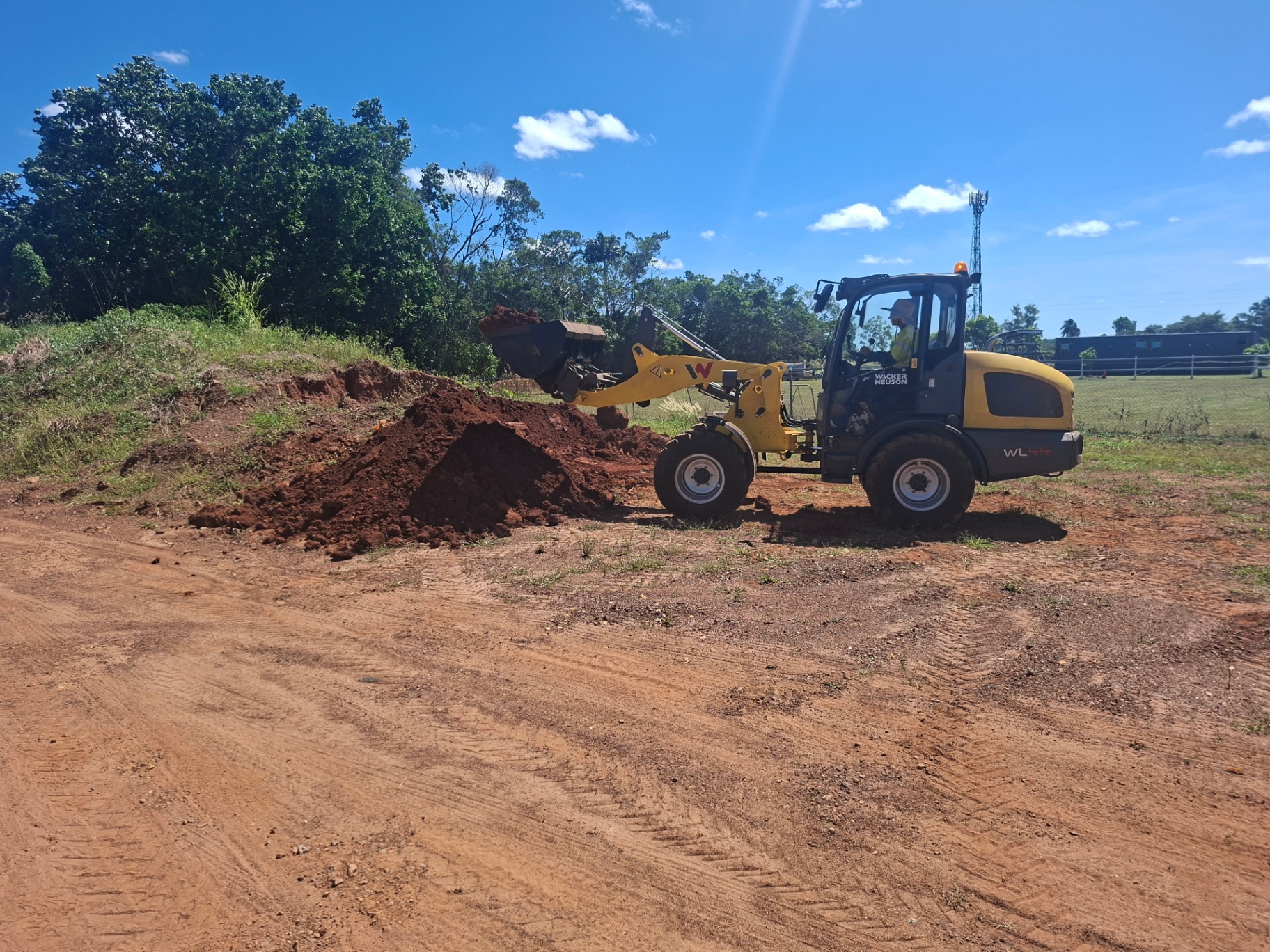 Wacker Neuson wheel loader pushing red dirt during practical earthworks training near Darwin